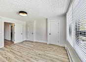 Thumbnail 31 of 54 - A room with white walls and wooden flooring with a window on the right side.