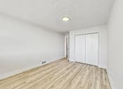 Thumbnail 29 of 54 - A room with a white door and wooden flooring.