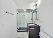 Thumbnail 44 of 54 - A bathroom with a sink, mirror, and shower.