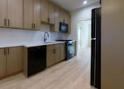 Thumbnail 5 of 13 - A kitchen with wooden cabinets and black appliances.