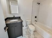 Thumbnail 38 of 54 - A bathroom with a sink, toilet, and bathtub.