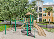 Thumbnail 42 of 46 - A playground with a green slide and a brown slide.