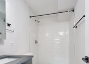 Thumbnail 41 of 54 - A white toilet sits in a bathroom with a white tile floor.