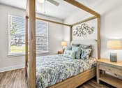 Thumbnail 10 of 37 - A bedroom with a four poster bed and a wooden nightstand.