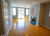 Thumbnail 3 of 14 - an empty living room with a fireplace and wooden floors