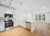 Thumbnail 40 of 60 - A modern kitchen with wooden floors and white cabinets.