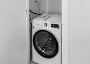 Thumbnail 43 of 54 - A white washing machine is in a white cabinet.