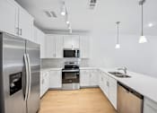 Thumbnail 41 of 60 - A modern kitchen with a stainless steel refrigerator and a dishwasher.