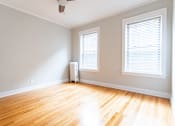 Thumbnail 21 of 24 - A room with wooden floors and a window with blinds.