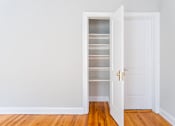 Thumbnail 24 of 24 - A white door with a gold handle is open to a white wall and a white shelving unit.