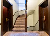 Thumbnail 6 of 24 - A staircase with a carpeted runner and wooden steps.