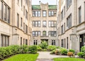 Thumbnail 2 of 24 - A courtyard surrounded by buildings with a green roof.
