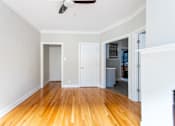 Thumbnail 20 of 24 - A room with a wooden floor and a ceiling fan.