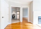 Thumbnail 19 of 24 - A kitchen with a white door and a white wall.