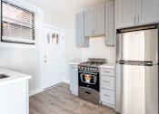 Thumbnail 9 of 24 - A kitchen with a stove, oven, and refrigerator.