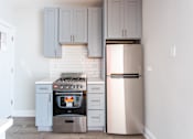 Thumbnail 8 of 24 - A kitchen with a stove and a refrigerator.