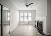 Thumbnail 16 of 24 - A room with a fireplace and a ceiling fan.
