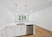Thumbnail 42 of 60 - A kitchen with white cabinets and a stainless steel dishwasher.