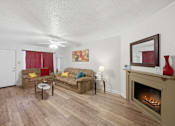 Thumbnail 7 of 37 - A living room with a fireplace and a painting on the wall.