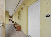 Thumbnail 31 of 46 - A hallway with a white door and a number 10 on the wall.