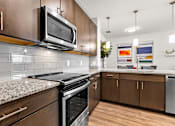 Thumbnail 17 of 37 - A modern kitchen with a granite countertop and stainless steel appliances.