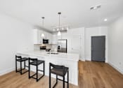 Thumbnail 15 of 60 - A kitchen with a white counter and black chairs.