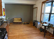 Thumbnail 7 of 13 - A kitchen with a black stove top oven and wooden floors.