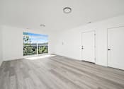 Thumbnail 8 of 27 - A room with a sliding glass door leading to a balcony.
