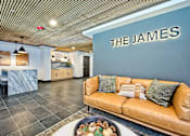 Thumbnail 8 of 9 - A living room with a couch and a sign that says "The James".