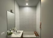 Thumbnail 10 of 45 - A bathroom with a white sink and a white bathtub.