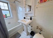 Thumbnail 6 of 17 - A white sink in a bathroom with a window.