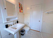 Thumbnail 7 of 17 - A white bathroom with a sink, toilet and a mirror.