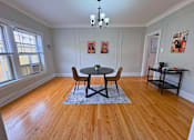 Thumbnail 10 of 17 - A dining room with a table and chairs.