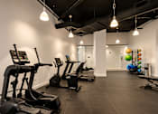 Thumbnail 10 of 18 - A gym with treadmills and exercise balls.