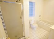Thumbnail 6 of 14 - a white bathroom with a toilet and a shower
