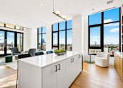 Thumbnail 1 of 18 - A modern office space with a large white desk and black chairs.