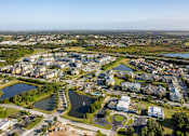 Thumbnail 11 of 37 - A bird's eye view of a residential area with a lake and a road.