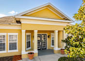 Thumbnail 4 of 37 - A yellow house with a brown roof and a glass door.