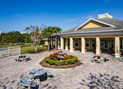 Thumbnail 6 of 37 - A building with a yellow roof and columns is surrounded by a circular garden with a bench.