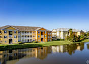 Thumbnail 3 of 37 - A large building with a yellow facade is reflected in the water in front of it.
