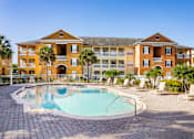 Thumbnail 14 of 37 - A large building with a pool in front.