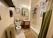 Thumbnail 9 of 25 - A bathroom with a toilet, sink, and bathtub.