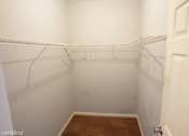 Thumbnail 4 of 14 - a white walk in closet with white shelves and a door