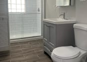 Thumbnail 6 of 14 - a bathroom with a toilet and a sink and a shower
