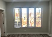 Thumbnail 4 of 14 - an empty living room with a window and wood floors