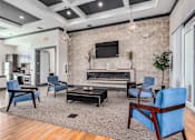 Thumbnail 3 of 35 - A living room with a fireplace and blue chairs.