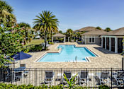Thumbnail 1 of 35 - A pool surrounded by a black fence and chairs.