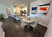 Thumbnail 23 of 35 - A dining room with a table and chairs.