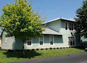 Thumbnail 17 of 24 - A green house with a tree in front of it.