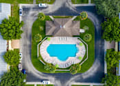 Thumbnail 2 of 24 - A bird's eye view of a residential area with a swimming pool and houses.